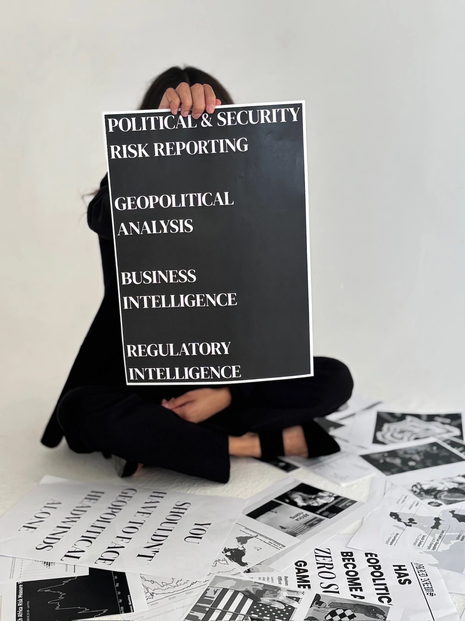 Aaliyah sitting on the floor holding a page up showing the services she offers